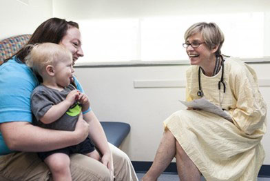 A Seattle Children's researcher talks to a mother and child.