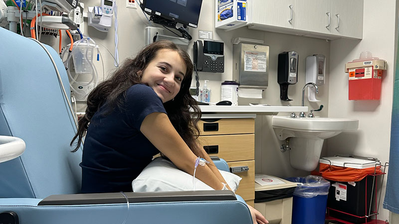 A girl sits in a hospital chair