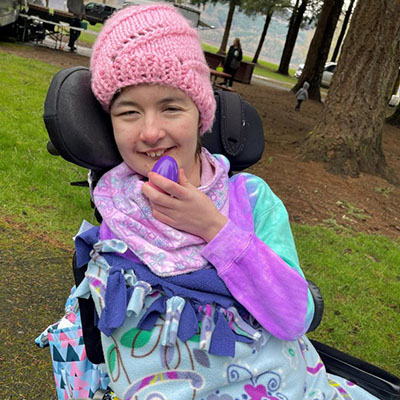 A girl in a wheelchair holds an Easter egg