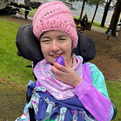 A girl in a wheelchair holds an Easter egg