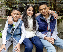 Three children sitting outside