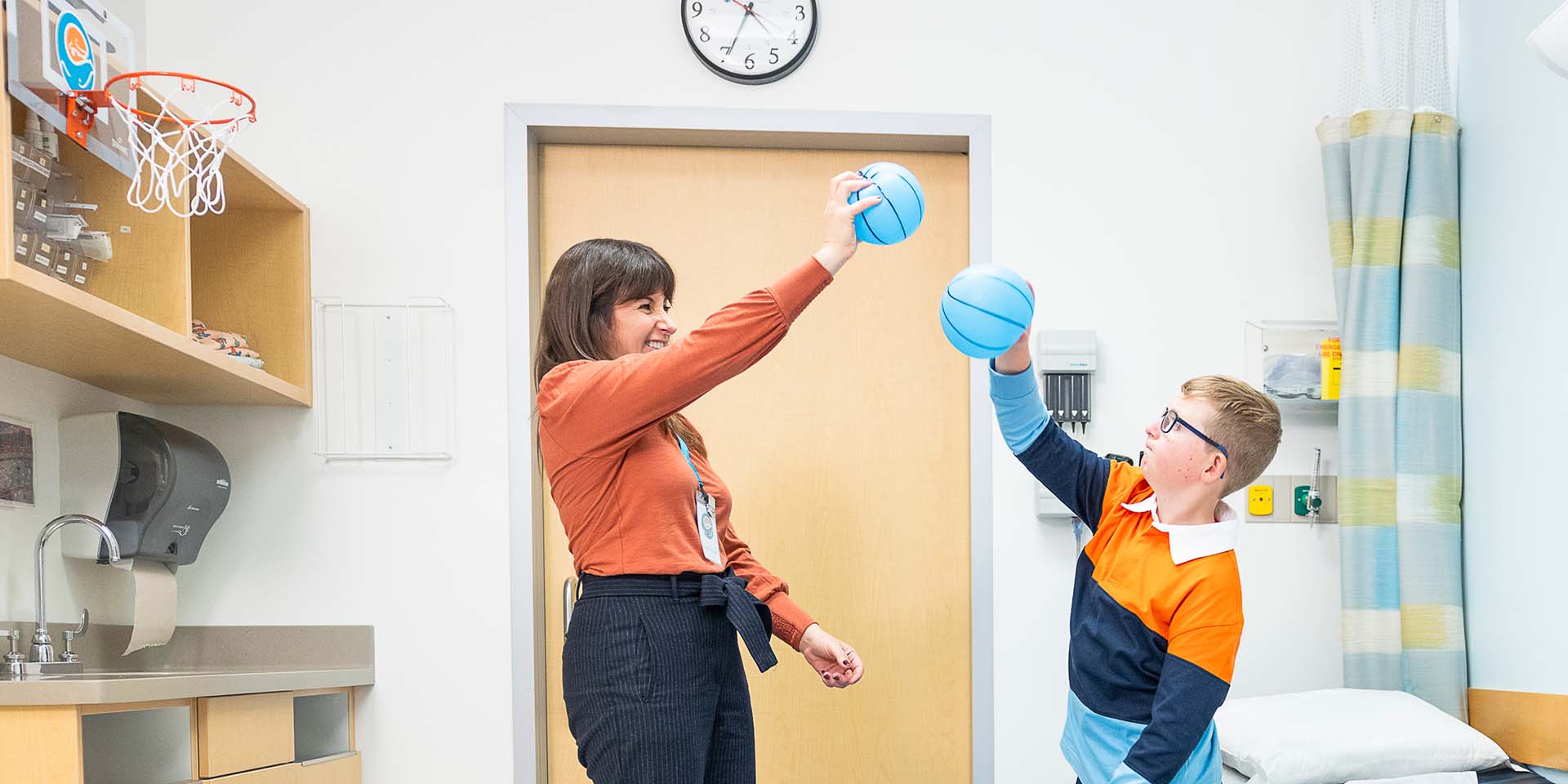 A doctor and patient play with toy basketballs