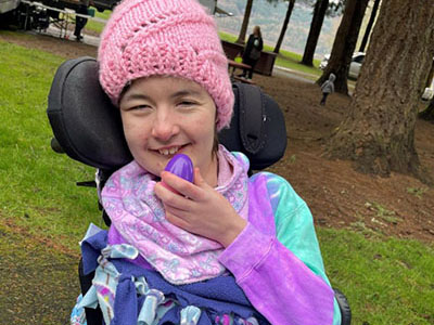 A girl in a wheelchair holds an easter egg