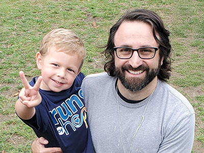 A Seattle Children's researcher holds a boy giving a peace sign