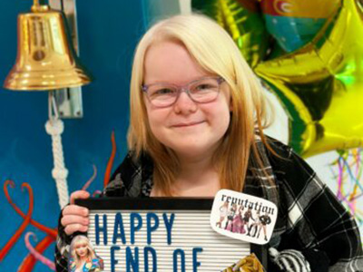 A girl wearing glasses holds a sign