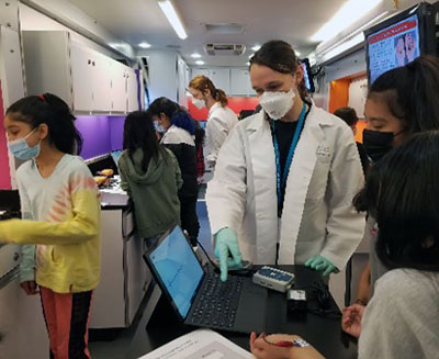 An instructor and students looking at a laptop