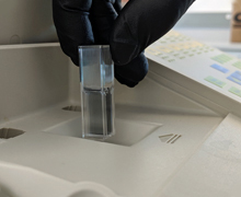 Student inserting a cuvette into a spectrophotometer