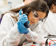 Student in lab glasses using equipment in Science Discovery Lab