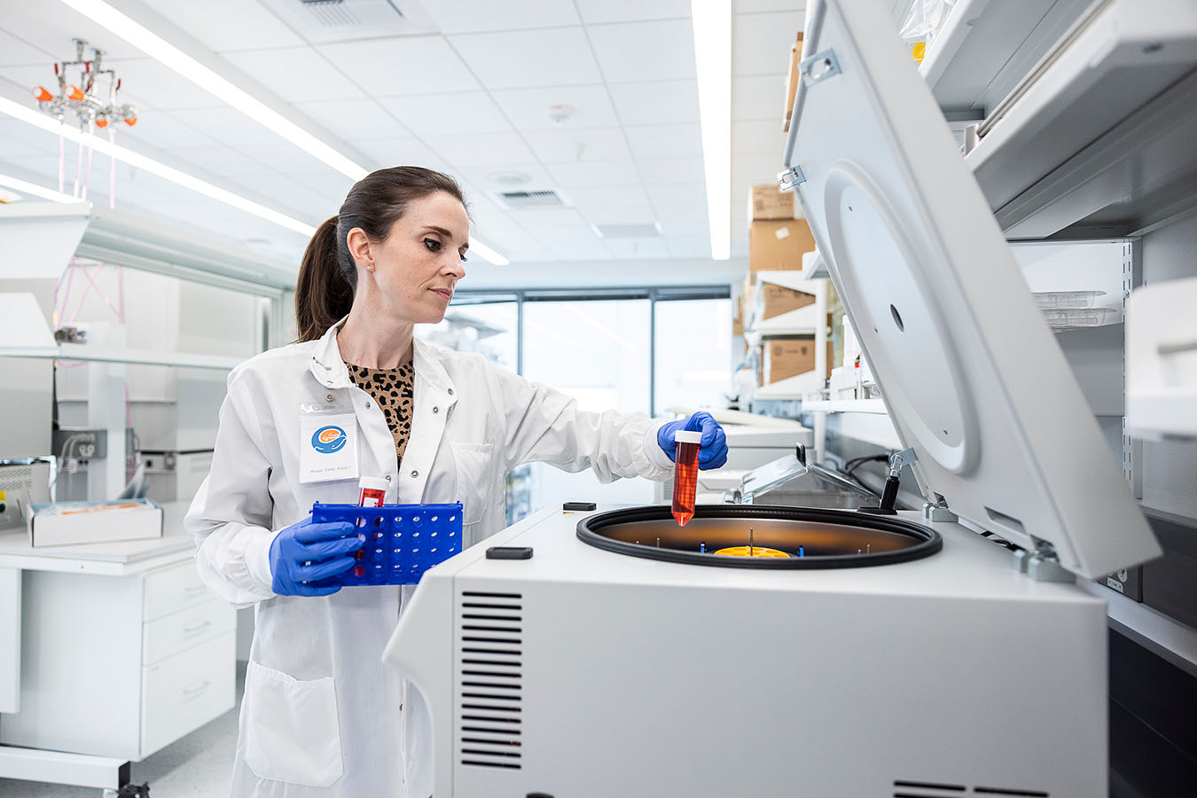 A researcher pulls a vial out of a centrifuge